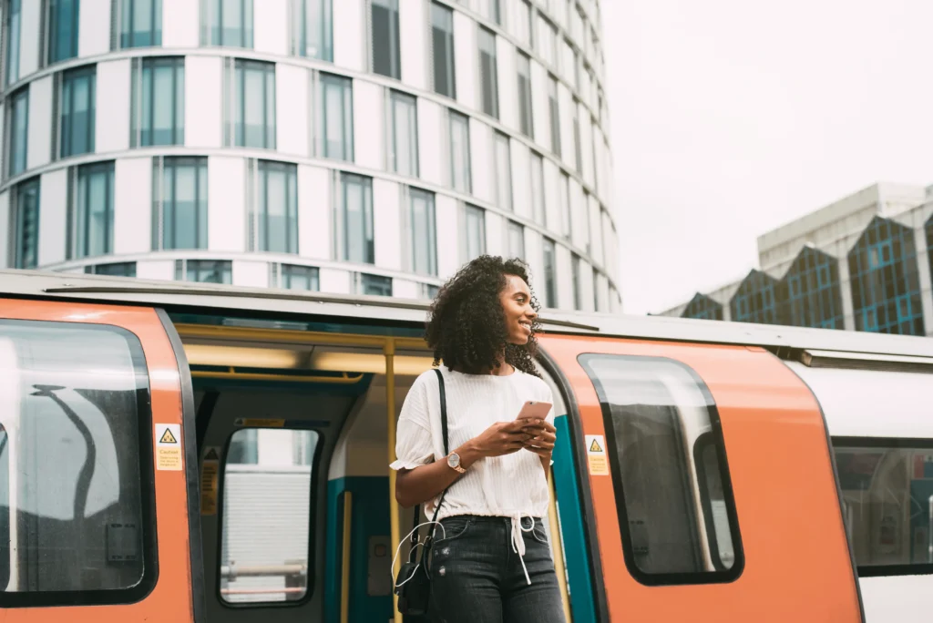 black woman using mobile phone london underground